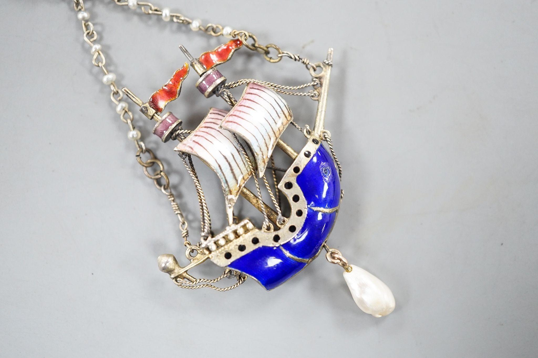 A 20th century continental gilt white metal, polychrome enamel, seed and baroque pearl set 'sailing ship' drop pendant, 48mm.